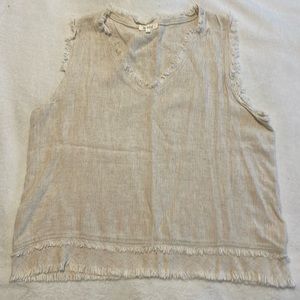 Cream colored sleeveless top with fringe on neckline, sleeves and bottom hem